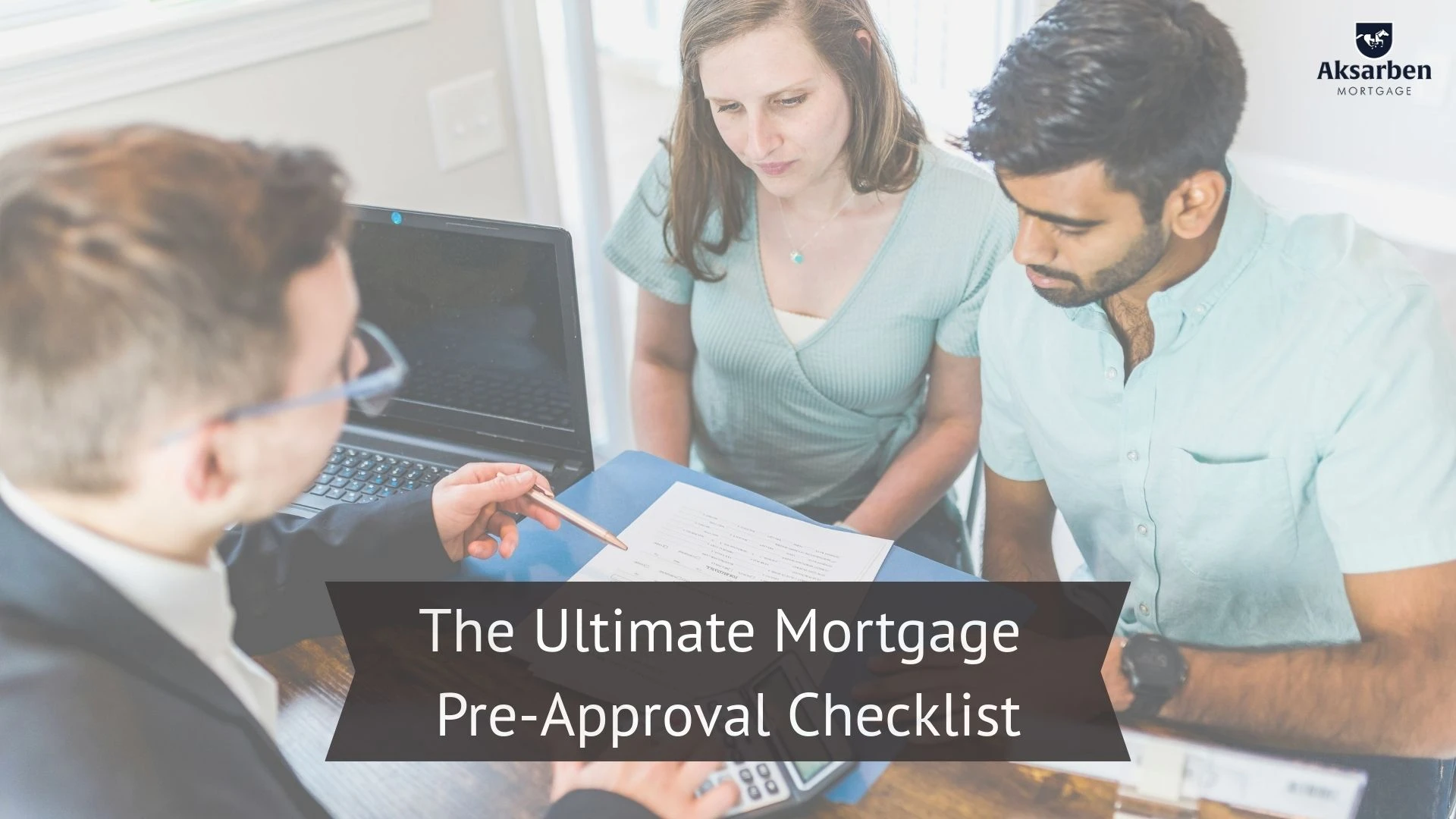 Couple reviewing mortgage documents with a loan officer during a pre-approval meeting.